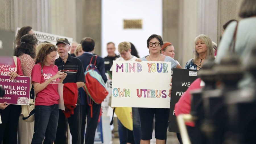 FILE - Protesters against a stricter ban on abortion in South Carolina stand in the Statehouse lobby on Tuesday, May, 23, 2023, in Columbia, South Carolina. South Carolina’s new all-male Supreme Court reversed course on abortion on Wednesday, Aug. 23, 2023, upholding a ban on most such procedures after about six weeks of pregnancy. (AP Photo/Jeffrey Collins, File)