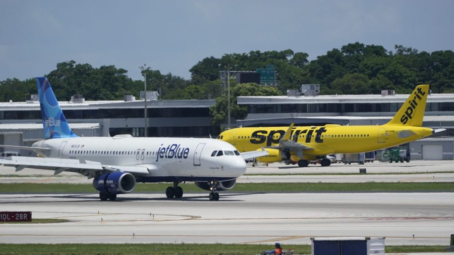 FILE - A JetBlue Airways Airbus A320, left, passes a Spirit Airlines Airbus A320 as it taxis on the runway, July 7, 2022, at the Fort Lauderdale-Hollywood International Airport in Fort Lauderdale, Fla. JetBlue Airways estimates that it could raise fares on some routes by up to 40% if it succeeds in buying Spirit Airlines and eliminating the low-fare carrier as a competitor on those routes, according to internal calculations that appeared in court filings. JetBlue said Thursday, Aug. 24, 2023, that information from the filings is being taken out of context to distort the facts. (AP Photo/Wilfredo Lee, File)