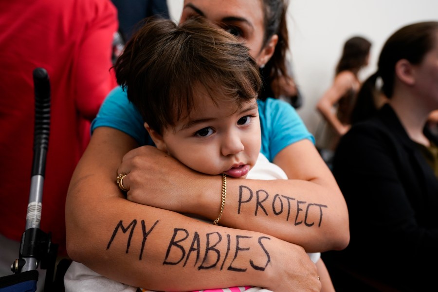 Melissa Alvarez hugs her son, Ignacio, 2, with the words "Protect My Babies" written on her arms in the House Civic Justice Committee of 1st Extraordinary Session meeting during a special session of the state legislature on public safety Wednesday, Aug. 23, 2023, in Nashville, Tenn. Tennessee Republican lawmakers hit an impasse Thursday just a few days into a special session sparked by a deadly school shooting in March, leaving little certainty about what they might ultimately pass, yet all but guaranteeing it won't be any significant gun control change. (AP Photo/George Walker IV)