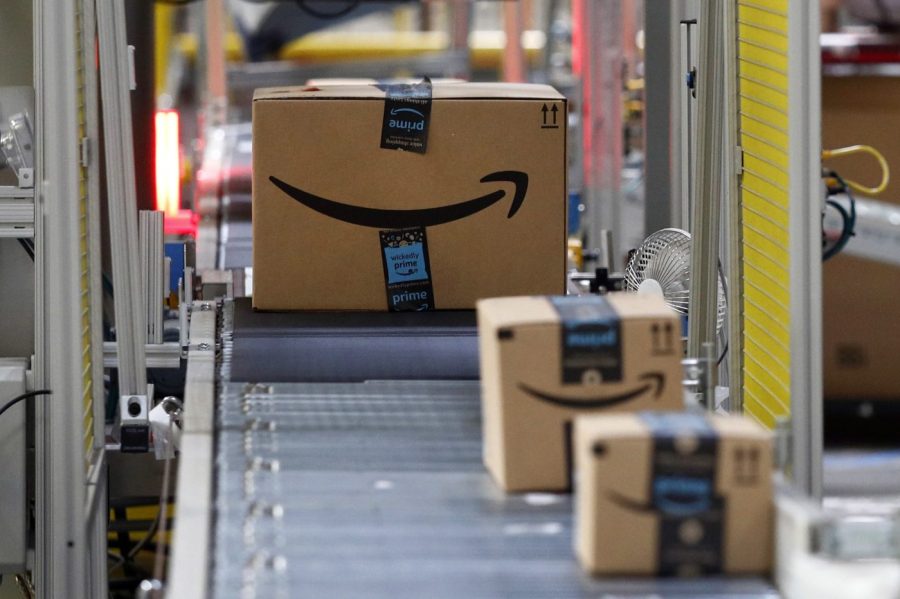 FILE - Packages pass through a scanner at an Amazon fulfillment center, Aug. 3, 2017, in Baltimore. Amazon has been quietly raising the amount some customers need to spend on its site to get free shipping. To qualify for no-cost deliveries, some Amazon customers who don’t have Prime memberships now need to spend $35, up from $25 previously. (AP Photo/Patrick Semansky, File)