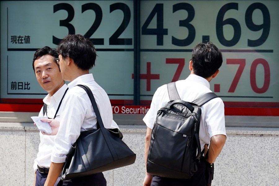 People stand in front of an electronic stock board showing Japan's Nikkei 225 index at a securities firm Tuesday, Aug. 29, 2023, in Tokyo. Asian shares mostly rose Tuesday as markets shift their attention from the U.S. Federal Reserve to earnings and economic reports (AP Photo/Eugene Hoshiko)