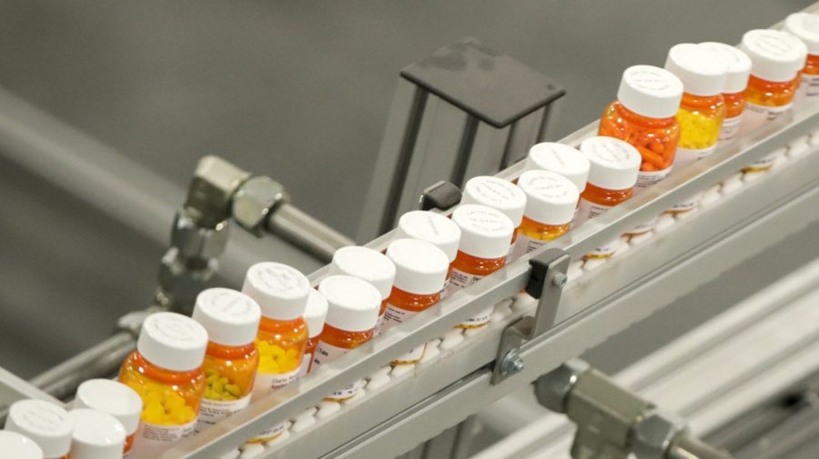 FILE- Bottles of medicine ride on a belt at a mail-in pharmacy warehouse in Florence, N.J., July 10, 2018. President Joe Biden's administration will announce on Tuesday, Aug. 29, 2023, the first prescription drugs being targeted by the U.S. government for price negotiations as part of an effort to lower Medicare costs. (AP Photo/Julio Cortez, File)