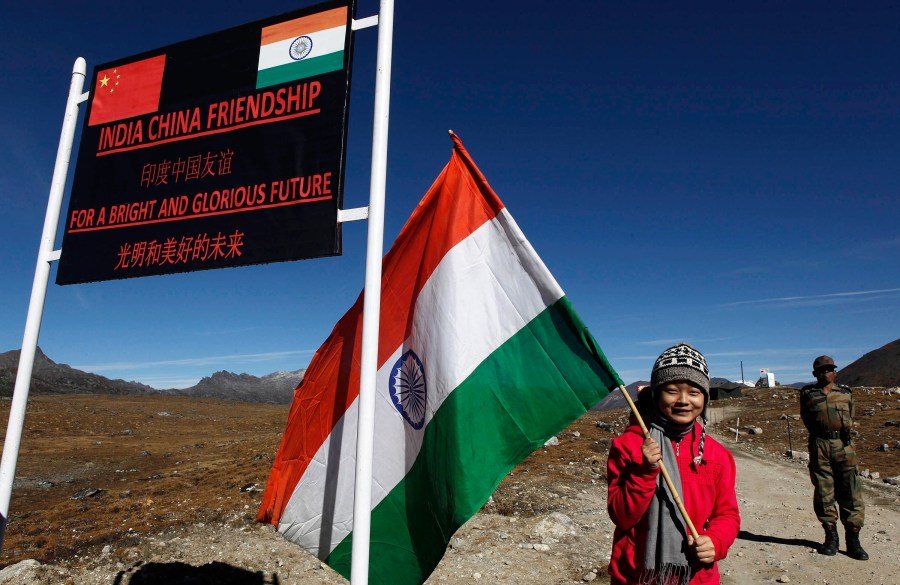 An Indian girl stands for photos with an Indian flag at the India- China border in Bumla, Arunachal Pradesh, India, Oct. 21, 2012. India is protesting a new Chinese map that lays claim to India’s territory ahead of next week's Group of 20 summit in New Delhi, a foreign ministry official said on Tuesday, Aug. 29, 2023, exacerbating tensions during a three-year military standoff between the two nations. China claims some 90,000 square kilometers of territory in India’s northeast, including Arunachal Pradesh. (AP Photo/Anupam Nath, File)