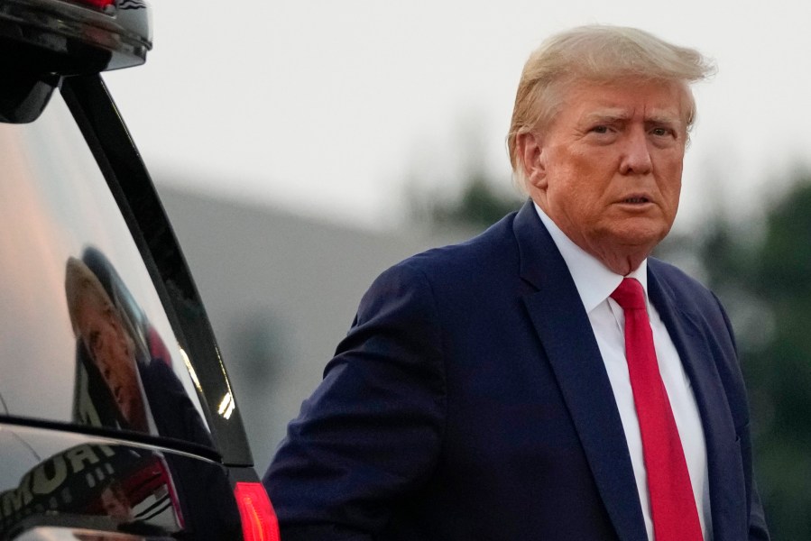 Former President Donald Trump walks to speak with reporters before departure from Hartsfield-Jackson Atlanta International Airport, Thursday, Aug. 24, 2023, in Atlanta. (AP Photo/Alex Brandon)