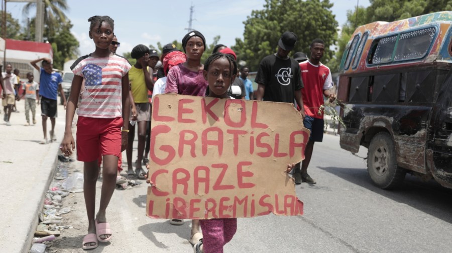 A girl carries a sign that reads in Creole "Free school is broken. Release the nurse," during a march to demand the freedom of New Hampshire nurse Alix Dorsainvil and her daughter, who have been reported kidnapped, in the Cite Soleil neighborhood of Port-au-Prince, Haiti, Monday, July 31, 2023.