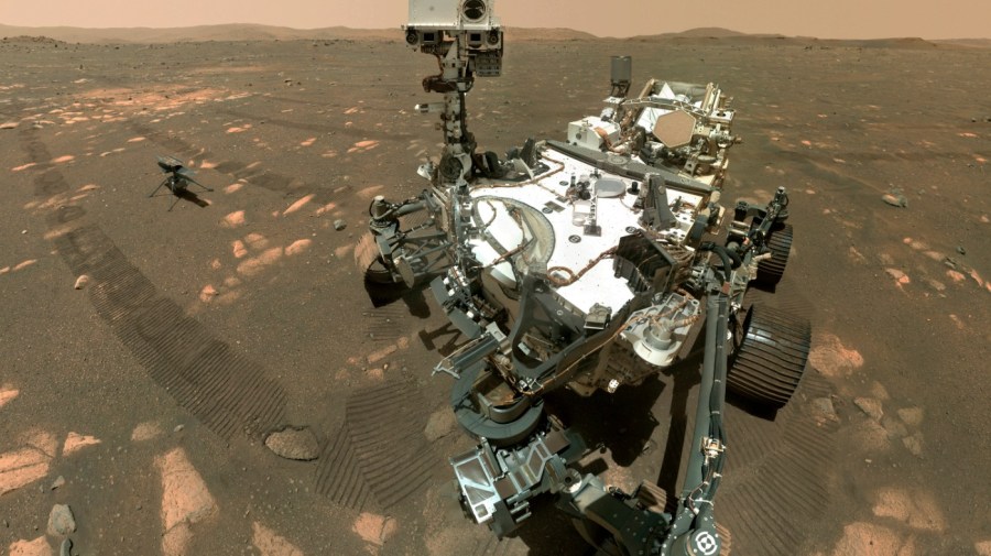 This Tuesday, April 6, 2021 image made available by NASA shows the Perseverance Mars rover, foreground, and the Ingenuity helicopter about 13 feet (3.9 meters) behind. This composite image was made by the WASTON camera on the rover's robotic arm on the 46th Martian day, or sol, of the mission. On Friday, Aug. 6, 2021, NASA’s newest Mars rover came up empty in its first attempt to pick up a rock sample to eventually be brought back to Earth. (NASA/JPL-Caltech/MSSS via AP)