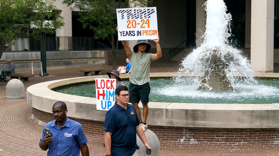 Protesters are seen outside the E. Barrett Prettyman United States District Court House