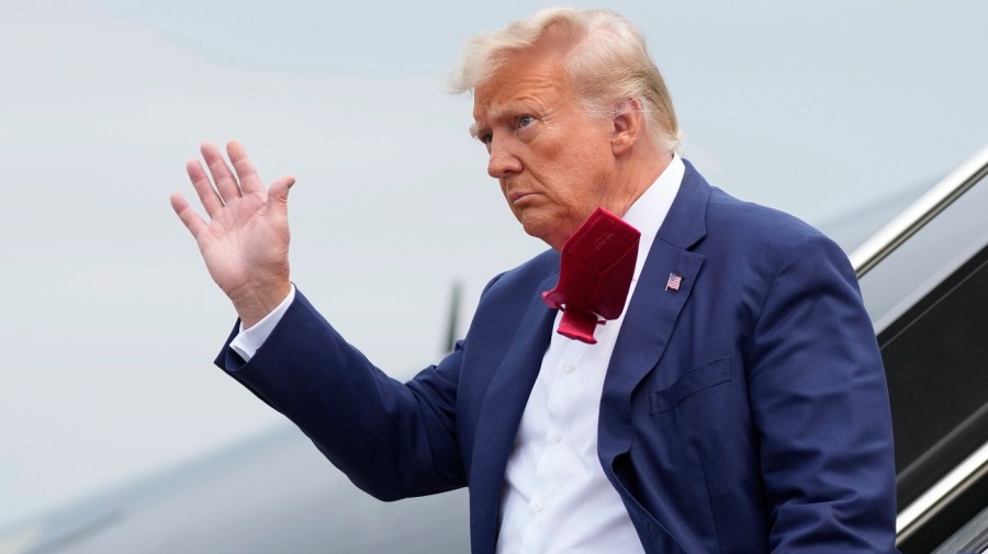 Former President Donald Trump waves as he steps off his plane at Ronald Reagan Washington National Airport, Aug. 3, 2023, in Arlington, Va. (AP Photo/Alex Brandon, File)