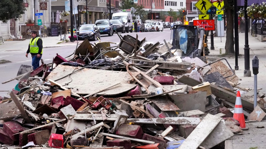 Flooding debris is stacked along State Street, near the state capital building, in downtown, Tuesday, Aug. 1, 2023, in Montpelier, Vt.