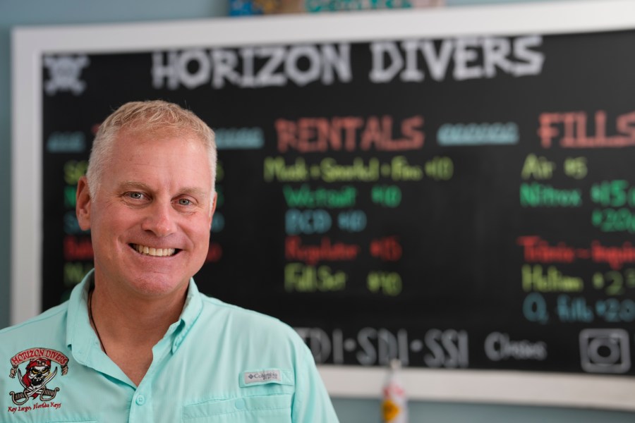 Dan Dawson, owner of Horizon Divers, poses for a picture inside his dive shop in Key Largo, Fla., Thursday, Aug. 17, 2023. Dawson saw business boom during the pandemic. Now it's back to pre-pandemic levels. (AP Photo/Rebecca Blackwell)