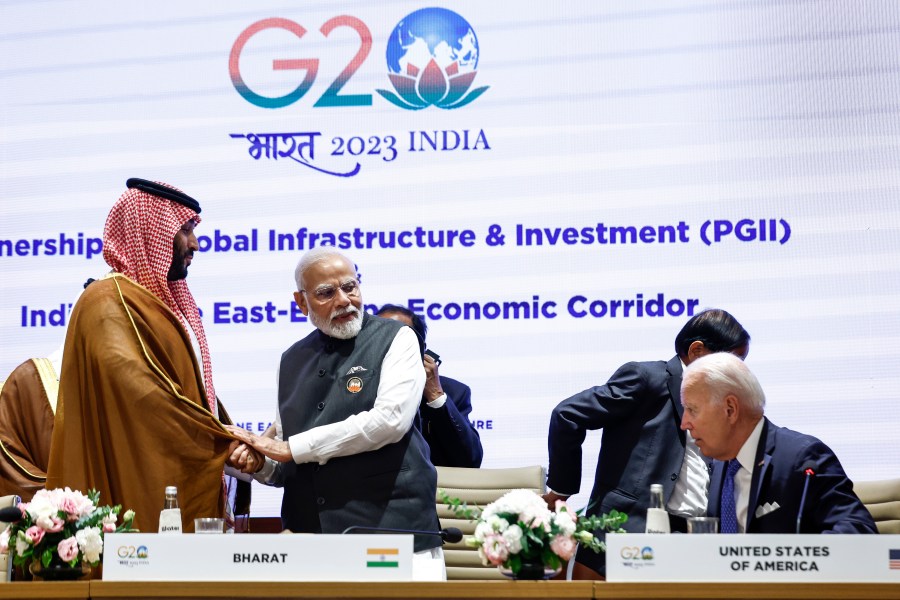 Saudi Arabian Crown Prince Mohammed bin Salman Al Saud, left, and Indian Prime Minister Narendra Modi shake hands next to U.S. President Joe Biden on the day of the G20 summit in New Delhi, India, Sept. 9, 2023. (AP Photo/Evelyn Hockstein, Pool)