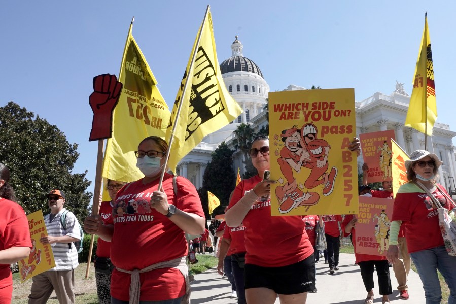 FILE -- Fast food workers and their supporters march past the California state Capitol in Sacramento, Calif., on Aug. 16, 2022. Most fast food workers in California would get a $20 minimum wage under a new bill introduced in the state Legislature on Monday, Sept. 11, 2023. The bill represents an agreement between labor unions and the fast food industry. (AP Photo/Rich Pedroncelli, File)