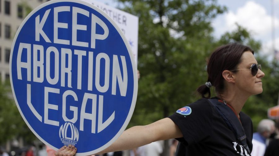 FILE - An. Abortion rights demonstrator holds a sign during a rally on May 14, 2022, in Chattanooga, Tenn. Women in Idaho, Tennessee and Oklahoma are challenging strict abortion laws that went into effect after the Supreme Court overturned Roe v. Wade last year. Two state lawsuits were filed on Tuesday, Sept. 12, 2023, in Idaho and Tennessee after women were denied care while facing harrowing pregnancy complications. Meanwhile, a federal complaint was filed in Oklahoma after a woman couldn't receive an abortion despite having a dangerous and nonviable pregnancy. (AP Photo/Ben Margot, File)