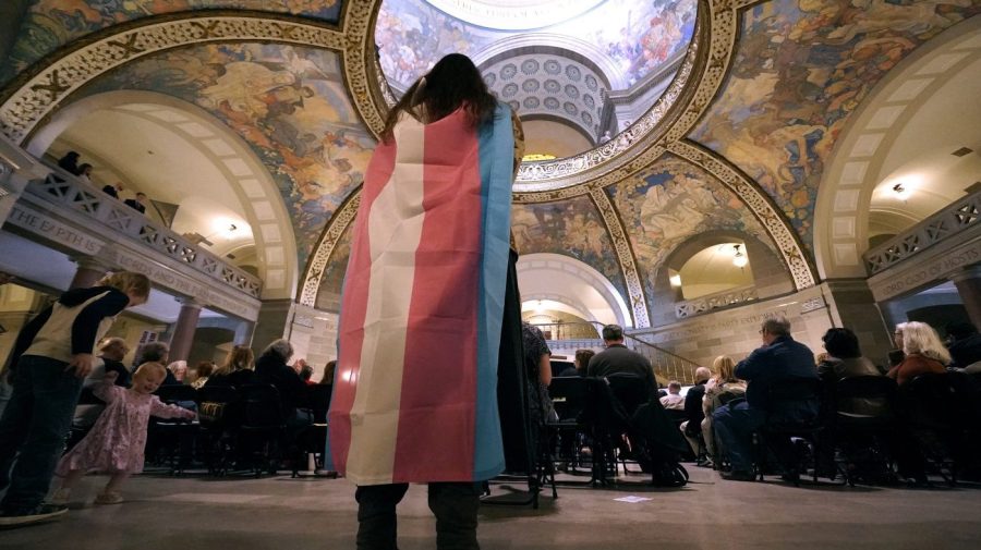 FILE - Glenda Starke wears a transgender flag as a counter protest during a rally in favor of a ban on gender-affirming health care legislation, March 20, 2023, at the Missouri Statehouse in Jefferson City.