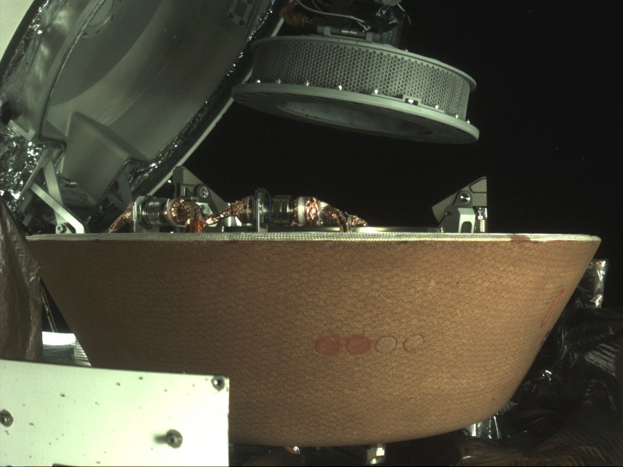 FILE - In this undated image provided by NASA, a sample container hovers over a capsule on the OSIRIS-REx spacecraft near the asteroid Bennu. On Sunday, Sept. 24, 2023, the OSIRIS-REx spacecraft will fly by Earth and drop off what is expected to be at least a cupful of rubble it grabbed from the asteroid Bennu, closing out a seven-year quest. (NASA via AP, File)