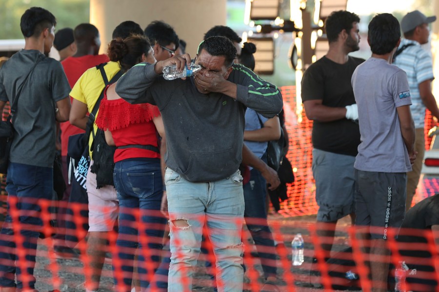 A migrant washes his face at a U.S. Border Patrol processing center under International Bridge II in Eagle Pass, Texas, Wednesday, Sept. 20, 2023. (Jerry Lara/The San Antonio Express-News via AP)