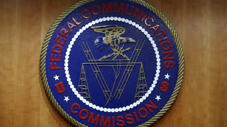 FILE - The seal of the Federal Communications Commission (FCC) is seen before an FCC meeting to vote on net neutrality, Dec. 14, 2017, in Washington. Landmark net neutrality rules rescinded under former President Donald Trump could return under a new push by FCC Chairperson Jessica Rosenworcel. The rules would reclassify broadband access as an essential service on par with other utilities like water or power. (AP Photo/Jacquelyn Martin, File)