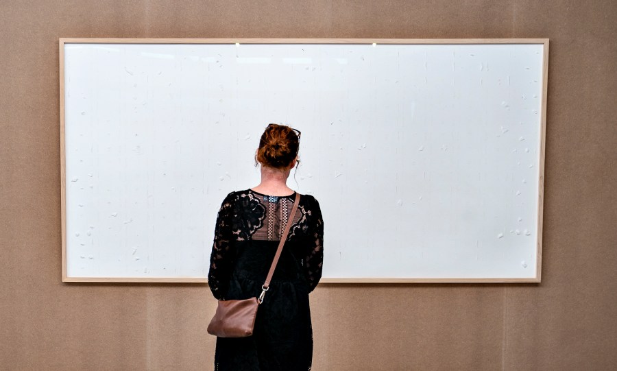 FILE - An empty picture frame by Danish artist Jens Haaning titled "Take the Money and Run", hangs at the Kunsten museum in Aalborg, on Sept. 28, 2021. Haaning, commissioned by the museum in northern Denmark to create a piece for its exhibition on labor conditions two years ago submitted two empty canvases. The exhibit caused a stir. A Danish court ruled last week that Jens Haaning has to repay 492,549 kroner ($69,894 ) to Kunsten Museum in Aalborg for the work. His lawyer, Peter Schønning, said Wednesday, Sept. 27, 2023, that the contemporary artist is appealing the ruling and declined further comment. (Henning Bagger/Ritzau Scanpix via AP)