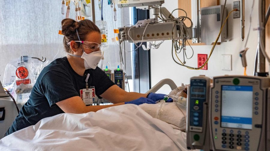 A medical worker treats a non-COVID-19 patient, who is just in a room besides rooms with COVID patients, in the ICU ward at UMass Memorial Medical Center in Worcester, Massachusetts on January 4, 2022.