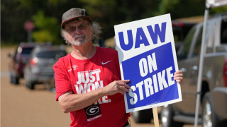 United Auto Workers member Ron Oglesby holds a picket sign outside the General Motors Customer Care and After-Sales facility in Brandon, Miss.