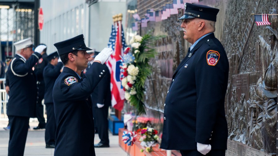 FILE — FDNY firefighters perform the changing of the guard at the FDNY Memorial Wall near the World Trade Center on Sunday, Sept. 11, 2016, on the 15th anniversary of the attacks in New York.