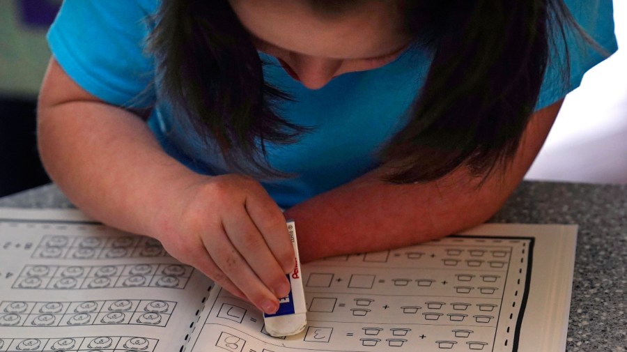 Lily Osgood, 7, corrects a math problem while studying at her family's home, Tuesday, July 20, 2021, in Fairfax, Vt.