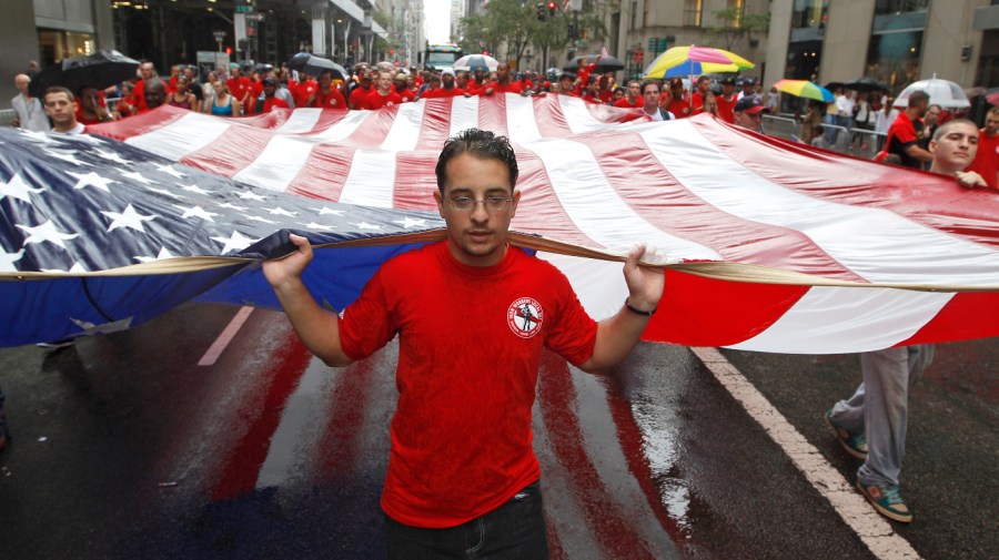 Local 361 iron worker Robert Farula marches up Fifth Ave. carrying an American flag during the Labor Day parade on Sept. 8, 2012 in New York.