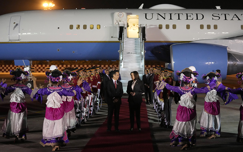 Vice President Harris talks with Indonesian Health Minister Budi Gunadi Sadikin as traditional dancers perform