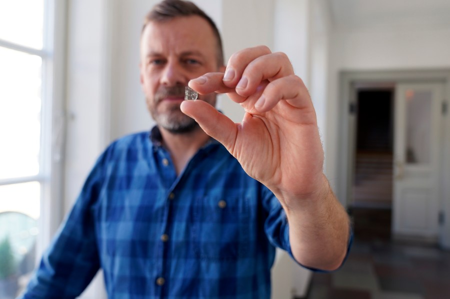 In this handout photo released on Thursday, Oct. 5, 2023, Senior Researcher at the National Museum of Denmark Mads Dengso Jessen holds a window glass fragment from the Viking Age, in Copenhagen, Denmark, Sept. 8, 2023. Over the past 25 years, archaeologists have found glass fragments in six excavations in southern Sweden, Denmark and northern Germany and have analyzed fragments of glass panes to reach the conclusion: Vikings had windows with glass-panes. (John Fhær Engedal Nissen/The National Museum of Denmark via AP)