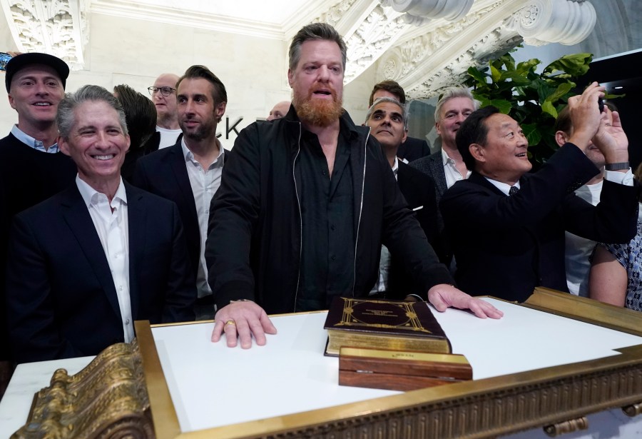 Birkenstock CEO Oliver Reichert, center, poses for photos on the New York Stock Exchange trading floor prior to ringing the opening bell before his company's IPO, Wednesday, Oct. 11, 2023. (AP Photo/Richard Drew)