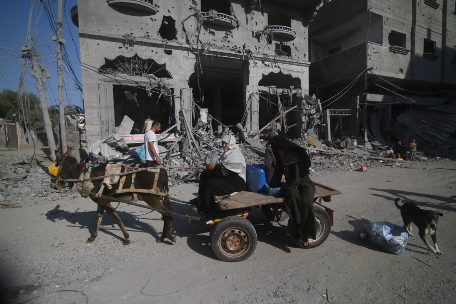 Palestinians leave their houses following Israeli airstrikes in Rafah refugee camp, southern Gaza Strip, Thursday, Oct. 12, 2023. (AP Photo/Hatem Ali)