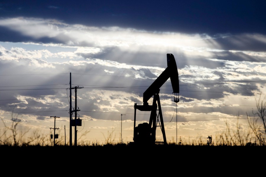 FILE - The sun shines through the clouds as it begins to set behind a pumpjack, March 30, 2022, outside of Goldsmith, Texas. United States domestic oil production has hit an all-time high, contrasting with efforts to slice heat-trapping carbon emissions by the Biden administration and world leaders. (Eli Hartman/Odessa American via AP, File)