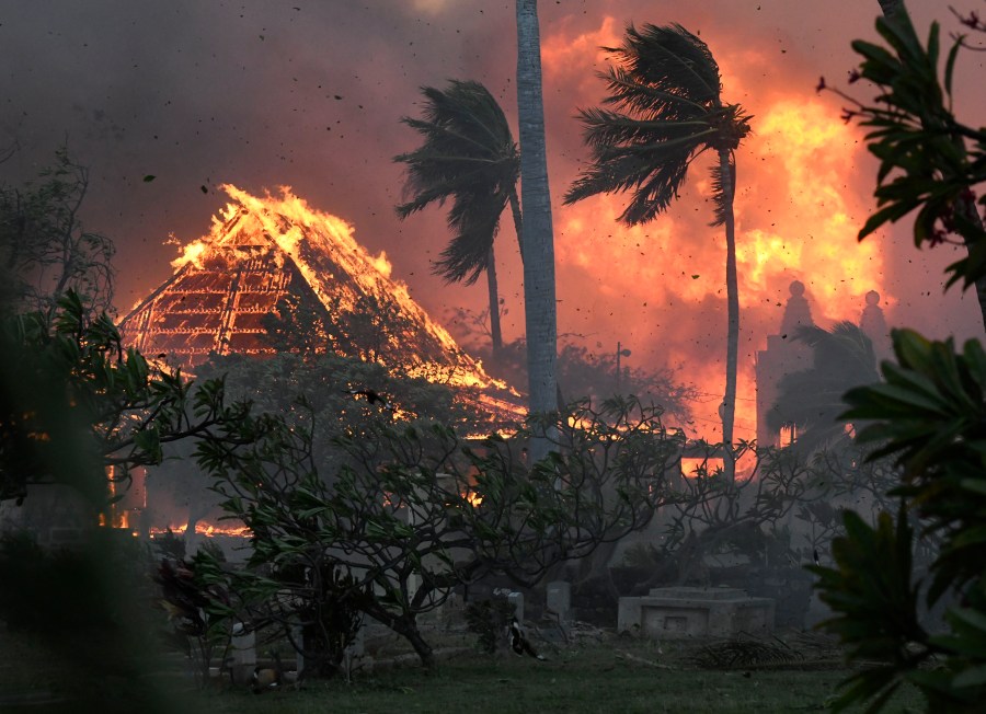 FILE - The hall of historic Waiola Church in Lahaina and nearby Lahaina Hongwanji Mission are engulfed in flames along Wainee Street on Aug. 8, 2023, in Lahaina, Hawaii. Communities still reeling from climate-fueled storms and other natural disasters, from the wildfires in Maui to severe flooding in New England, fear a federal government shutdown will delay needed disaster relief.(Matthew Thayer/The Maui News via AP, File)