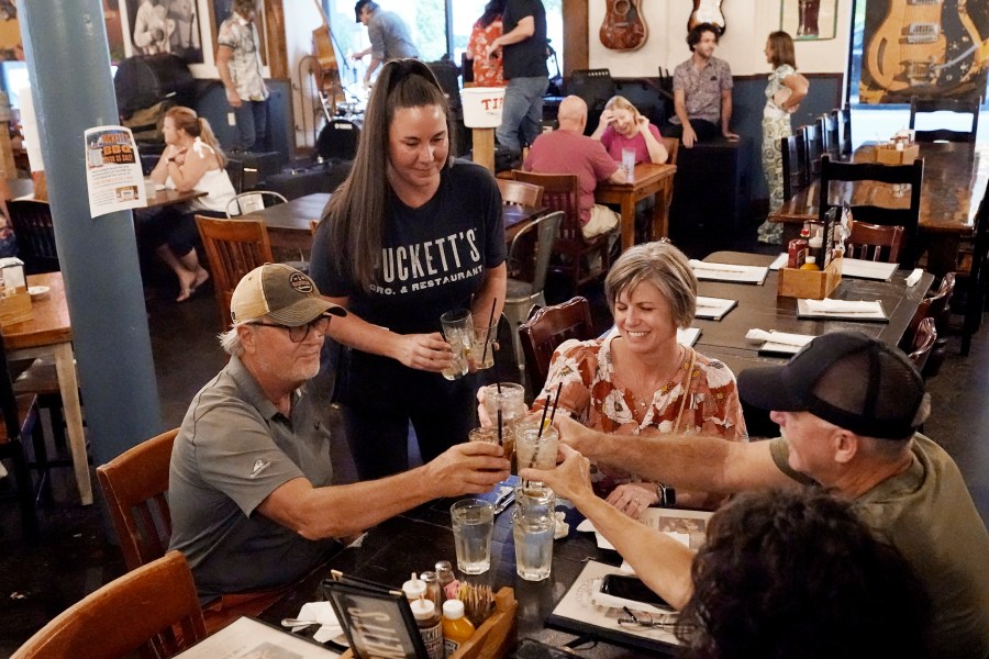 FILE - Macy Norman, center, serves a table of guests at Puckett's Grocery and Restaurant, on Sept. 10, 2021, in Nashville, Tenn. The net worth of the typical U.S. household grew at the fastest pace in more than three decades from 2019 through 2022, while low interest rates made it easier for households to pay their debts, according to a government report Wednesday. (AP Photo/Mark Humphrey, File)
