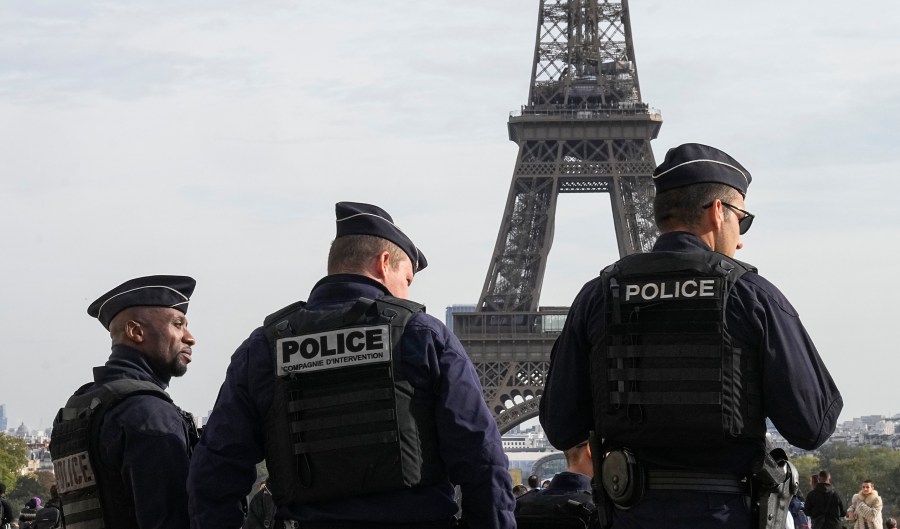 FILE - Police officers patrol the Trocadero plaza near the Eiffel Tower in Paris, Tuesday, Oct. 17, 2023. Police have arrested a man climbing on the Eiffel Tower. The drama temporarily stranded a crowd at the top. Among those trapped was a Washington, D.C., couple who decided during the wait to get married and an Associated Press reporter who got their story. Amir Khan had been planning to propose to Kate Warren later Thursday in a Paris garden away from the crowds, with a romantic dinner on the River Seine also on his menu. (AP Photo/Michel Euler, File)