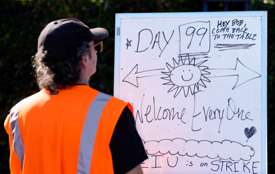 FILE - SAG-AFTRA captain Demetri Belardinelli looks over a bulletin board commemorating the 99th day of the actors' strike, Friday, Oct. 20, 2023, outside Walt Disney Studios in Burbank, Calif. Saturday marks the 100th day that film and TV performers from the Screen Actors Guild-American Federation of Television and Radio Artists have been on strike, seeking changes to compensation and protections from use of artificial intelligence in their craft. (AP Photo/Chris Pizzello, File)