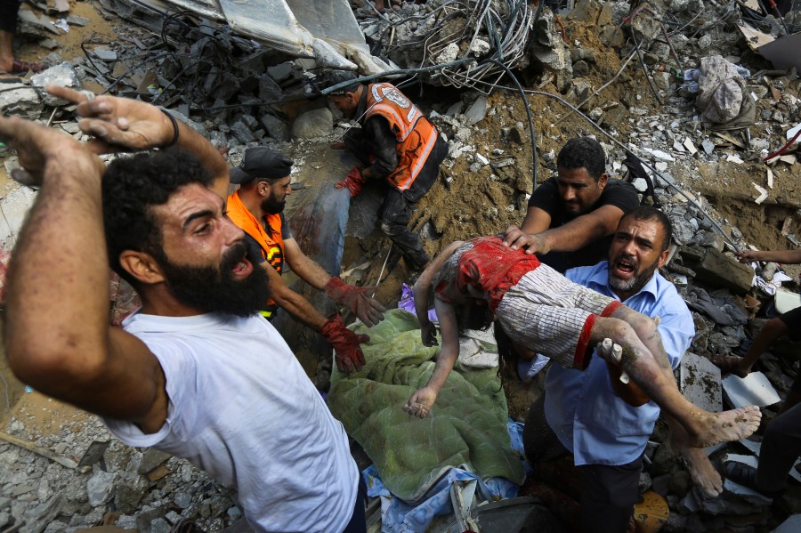 Palestinians carry a body of a dead child who was found under the rubble of a destroyed house after Israeli airstrikes on Gaza City, Tuesday, Oct. 24, 2023. (AP Photo/Abed Khaled)