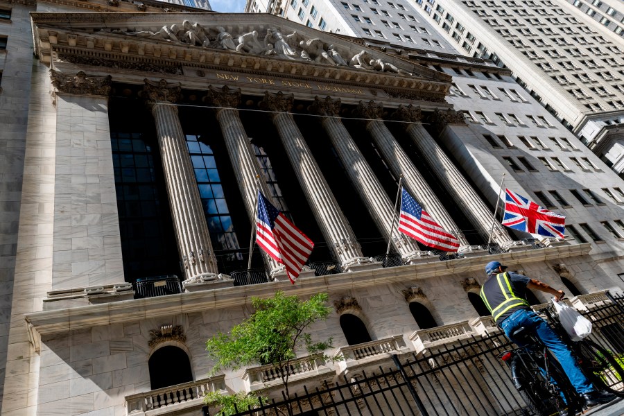 A man rides on a bicycle past the New York Stock Exchange, Tuesday, Sept. 13, 2022, in New York. (AP Photo/Julia Nikhinson)