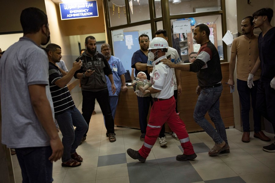 A Palestinian medic carries a baby wounded in the Israeli bombardment of the Gaza Strip into a hospital in Khan Younis, Saturday, Oct. 21, 2023. (AP Photo/Fatima Shbair)