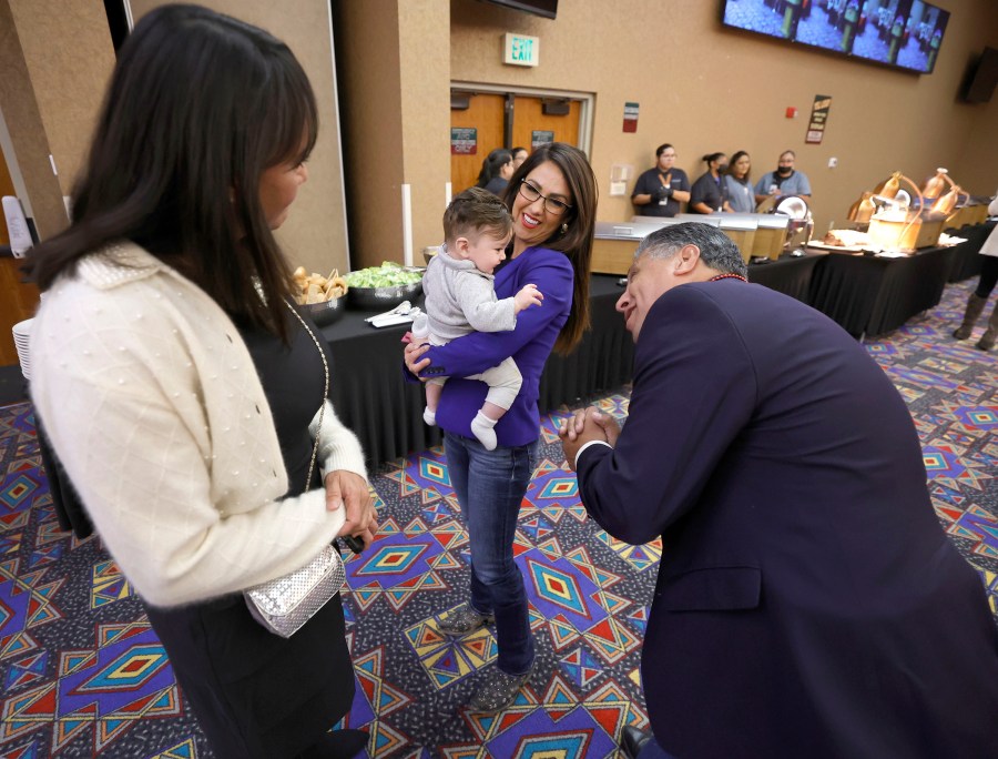 Rep. Lauren Boebert, R-Colo., center, holds her 6-month-old grandson, Josiah Boebert, as Greg Lopez, president and CEO of the Colorado Hispanic Republicans, right, smiles at the baby and Tish Haidet looks on, Saturday, Oct. 28, 2023, in Towaoc, Colo., before speaking at the Montezuma County Lincoln Day Dinner at the Ute Mountain Casino Hotel. (AP Photo/Jerry McBride)