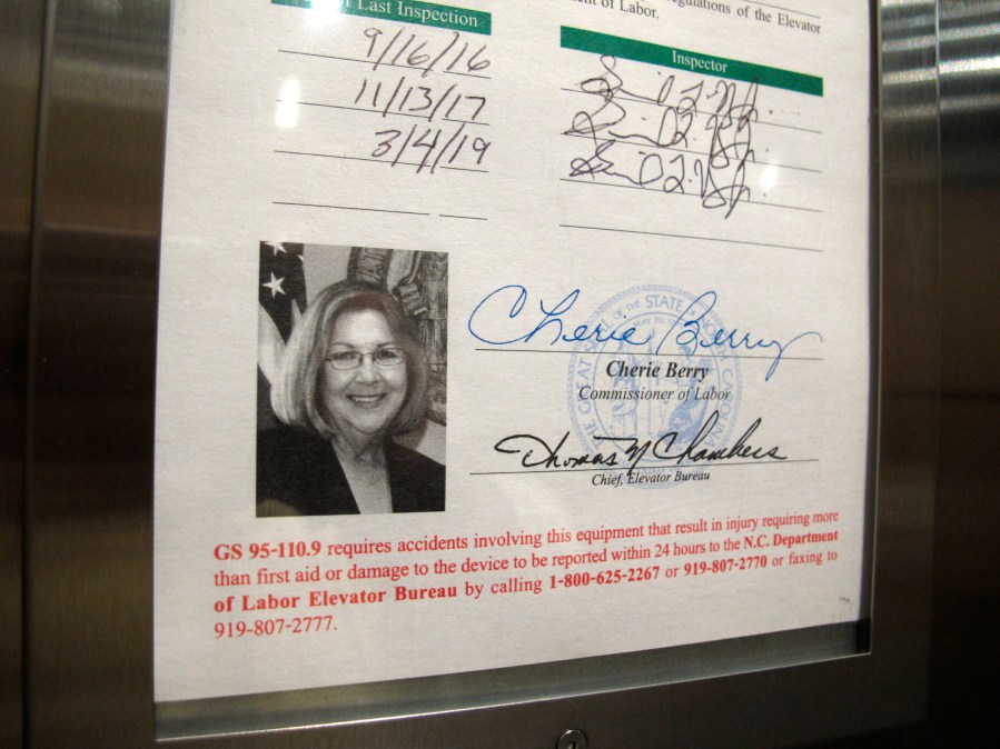 FILE - A photo of North Carolina Labor Commissioner Cherie Berry is displayed on an elevator inspection certificate, April 2, 2019, in Raleigh, N.C. More elevator riders in North Carolina soon won't see the state labor commissioner staring back at them. Commissioner Josh Dobson had followed longtime predecessor Berry’s practice of inscribing his photo onto elevator inspection certificates, but he said Monday, Oct. 30, 2023, that his photo is being eliminated to make way for a recently redesigned form. (AP Photo/Allen G. Breed, File)