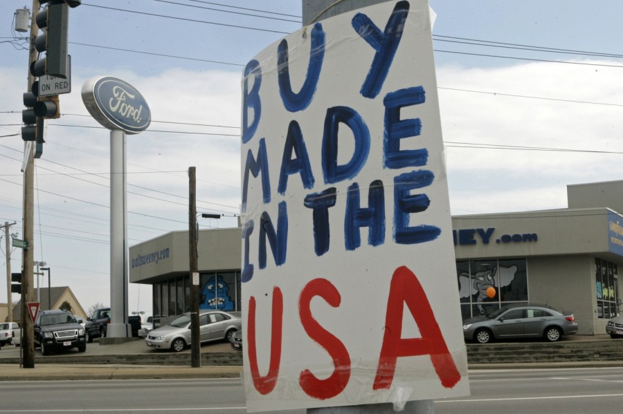 A hand made sign saying "Buy made in the USA" is posted on a street next to the Walt Sweeney Ford dealership, Wednesday, Feb. 25, 2009, in Cincinnati. (AP Photo/Al Behrman)