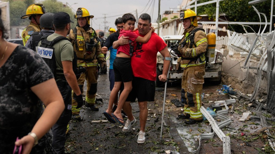 Israelis evacuate a site struck by a rocket fired from the Gaza Strip, in Ashkelon, southern Israel, Monday, Oct. 9, 2023.