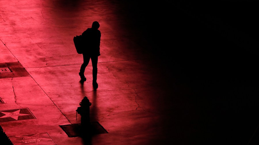 A person walks along the Las Vegas Strip devoid of the usual crowds after casinos have been ordered to shut down due to the coronavirus, March 18, 2020, in Las Vegas.