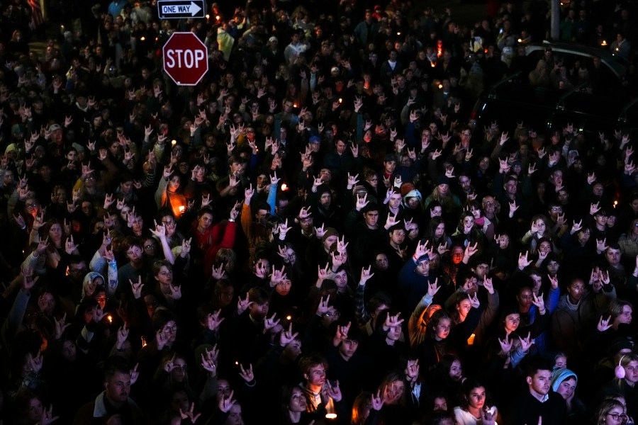 FILE - People sign "I love you," while gathered at a vigil for the victims of mass shootings days earlier, Sunday, Oct. 29, 2023, outside the Basilica of Saints Peter and Paul in Lewiston, Maine. Two senators from Maine are asking the U.S. Army inspector general to provide a full accounting of interactions with a reservist before he killed multiple people at a bowling alley and bar. (AP Photo/Matt Rourke, File)