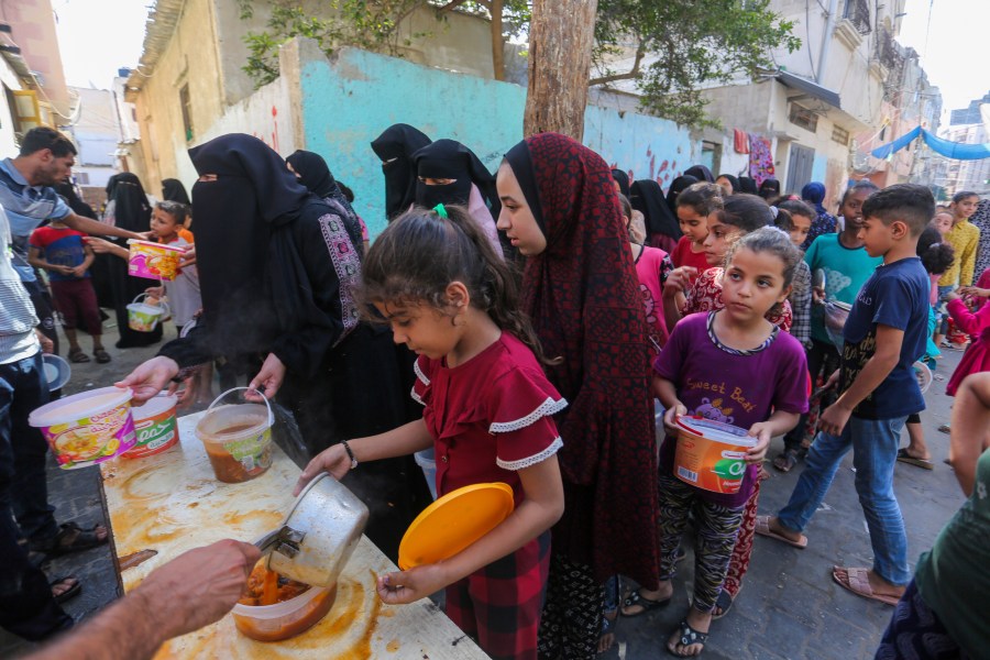 Palestinians receive food in Rafah, southern Gaza Strip, Wednesday, Nov. 8, 2023. Since the start of the Israel-Hamas war, Israel has limited the amount of food and water allowed to enter the territory, causing widespread hunger across the strip (AP Photo/Hatem Ali)