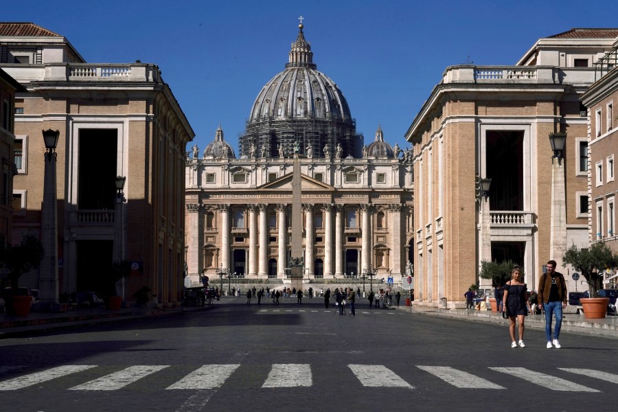 FILE - A view of St. Peter's Basilica at the Vatican, March 11, 2020. In the United States, the national conference of Catholic bishops rejects the concept of gender transition, leaving many transgender Catholics feeling excluded. On Wednesday, Nov. 8, 2023, the Vatican made public a sharply contrasting statement, saying it’s permissible, under certain circumstances, for trans Catholics to be baptized and serve as godparents. (AP Photo/Andrew Medichini, File)