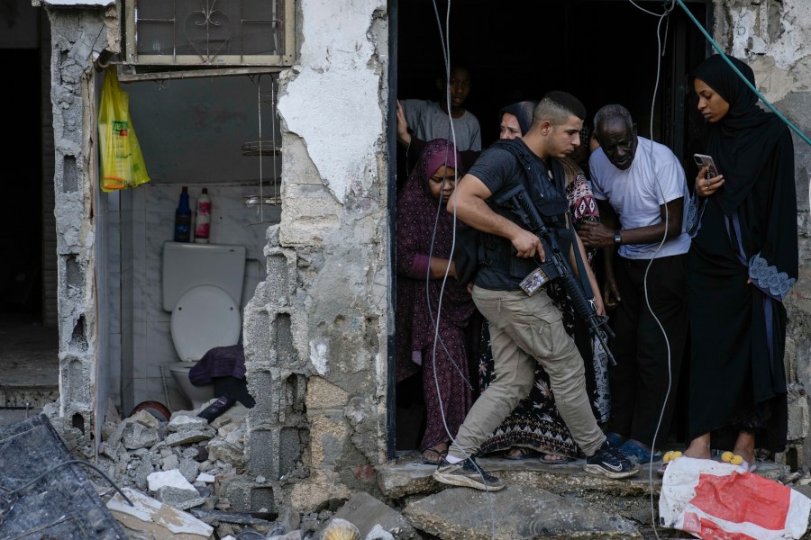 A Palestinian militant walks following an Israeli military raid on the town of Tulkarem, West Bank, Tuesday, Nov. 14, 2023. At least seven Palestinians were killed overnight during an Israeli raid, the Palestinian Health Ministry said Tuesday. The Israeli army said it killed a number of militants during an exchange of fire. AP Photo/Majdi Mohammed)