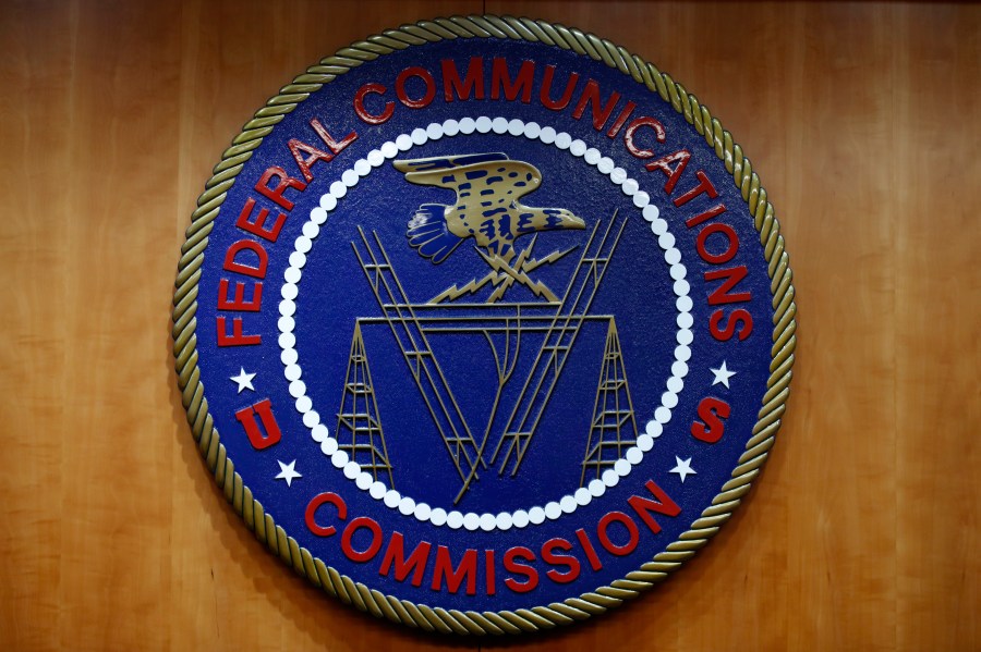 The seal of the Federal Communications Commission is seen on a wall.