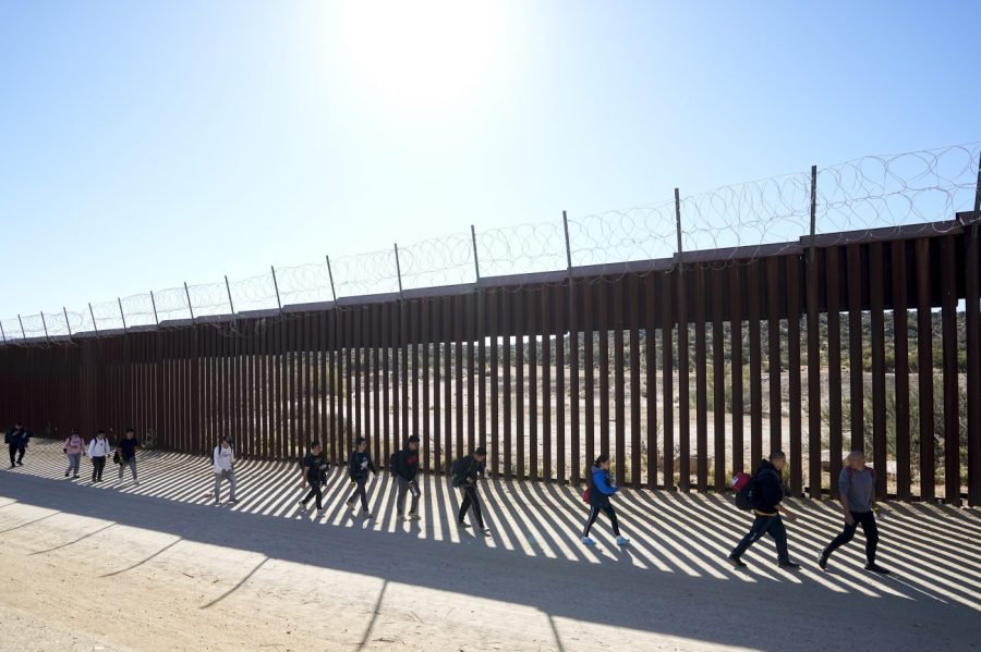 FILE - A group of people, including many from China, walk along the wall after crossing the border with Mexico to seek asylum, Tuesday, Oct. 24, 2023, near Jacumba, Calif. As Congress returns this week, Senate Republicans have made it clear they won’t support additional war aid for Ukraine unless they can pair it with border security measures. (AP Photo/Gregory Bull, File)